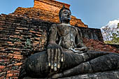 Thailand, Old Sukhothai - Wat Mahathat, square-based, multi-layered chedi with statues of seated Buddha at each side, stucco figures of lions and elephants decorate the base. 